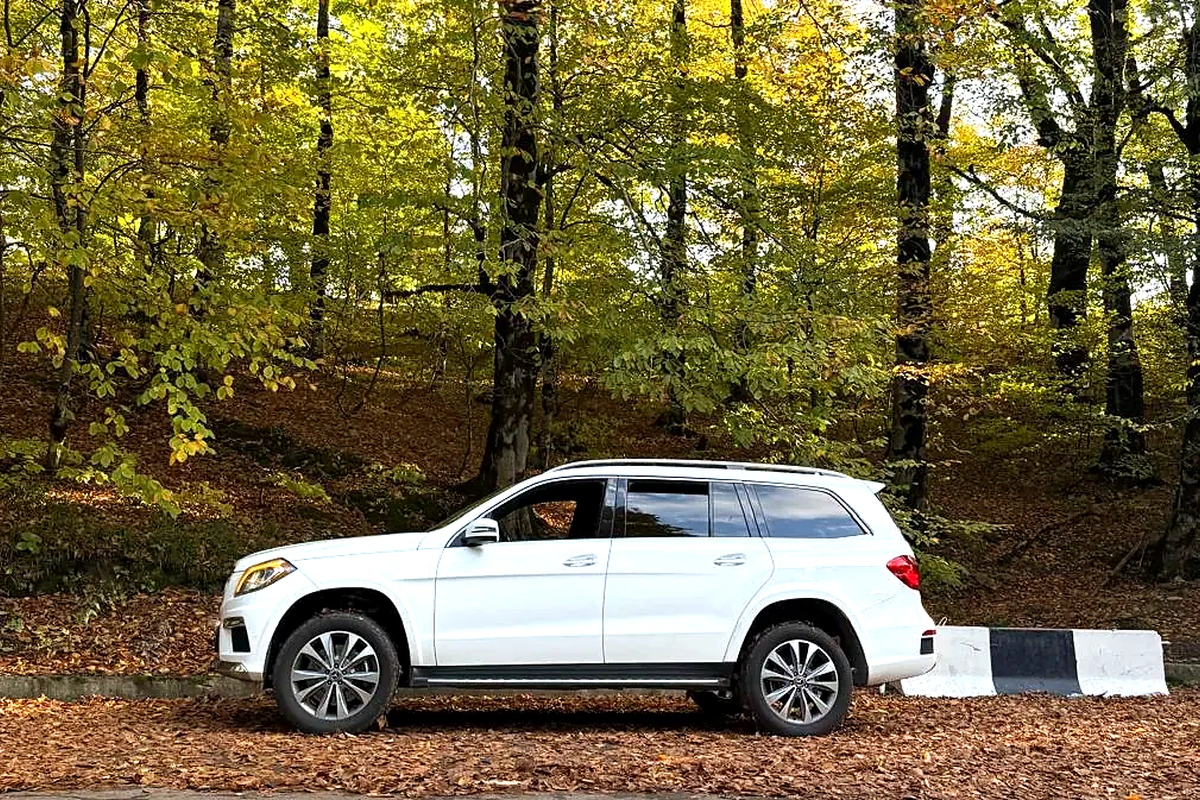 Белый Mercedes-Benz GL 350 в осеннем лесу