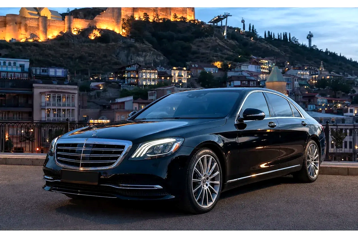 Чёрный Mercedes-Benz S 450 на фоне вечернего Тбилиси