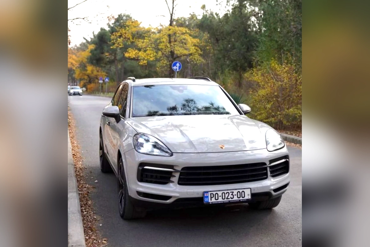 Серый Porsche Cayenne S на осенней дороге
