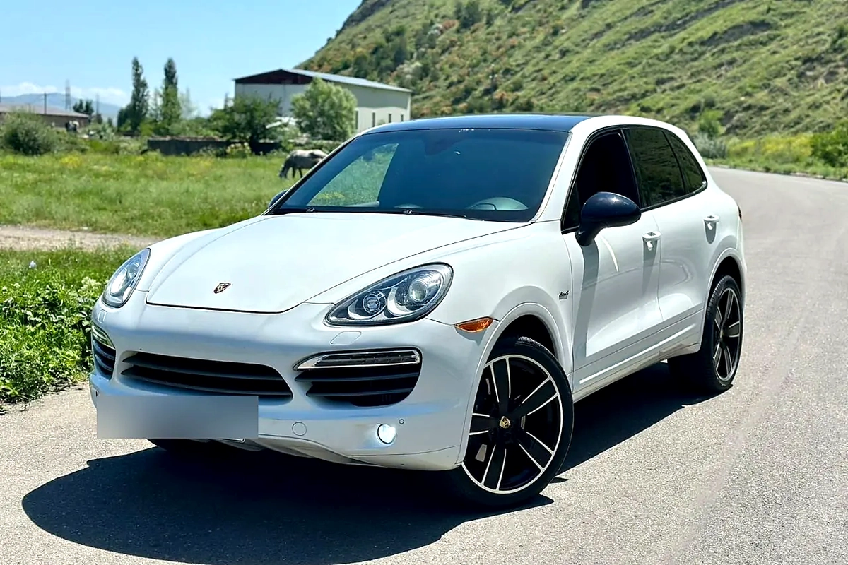 Белый Porsche Cayenne на дороге в Грузии