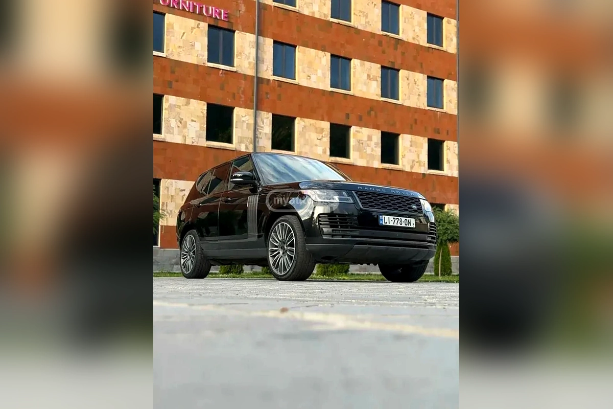 Чёрный Range Rover Vogue у кирпичного здания